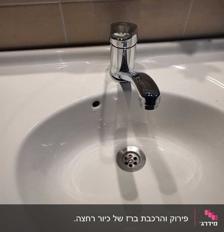 ברז כרום מעל כיור לבן עם ניקוז